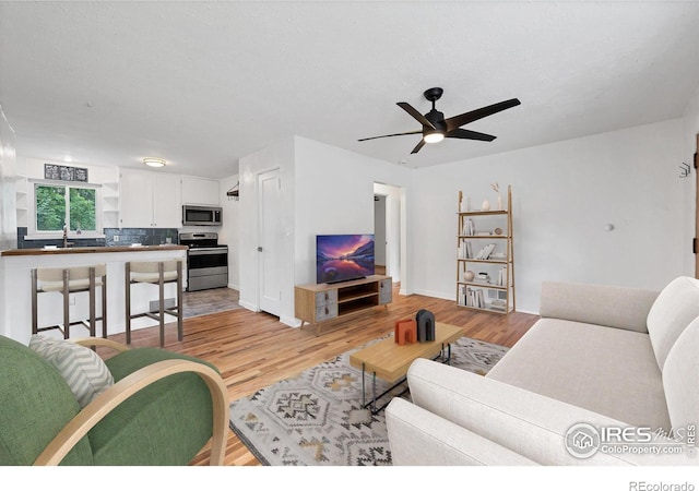 6755 W 33rd Ave, Wheat Ridge, CO 80033 - living room featuring light wood finished floors and ceiling fan