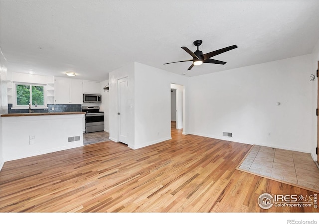 6755 W 33rd Ave, Wheat Ridge, CO 80033 - unfurnished living room featuring light wood-style flooring and ceiling fan