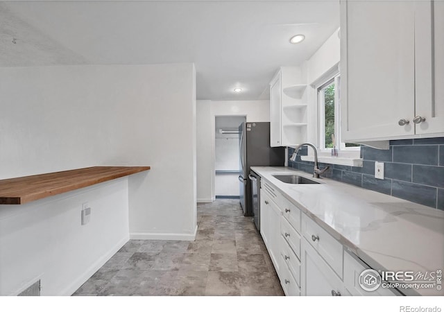 6755 W 33rd Ave, Wheat Ridge, CO 80033 - kitchen with open shelves, white cabinets, light stone counters, decorative backsplash, and stainless steel dishwasher