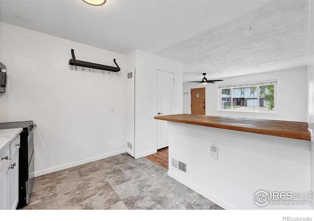 6755 W 33rd Ave, Wheat Ridge, CO 80033 - kitchen featuring wood counters, electric range, ceiling fan, and white cabinets