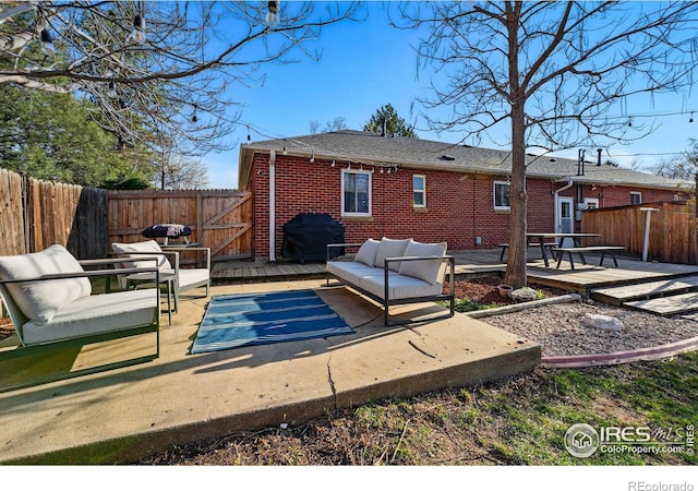 6755 W 33rd Ave, Wheat Ridge, CO 80033 - rear view of property featuring a deck, brick siding, and a fenced backyard