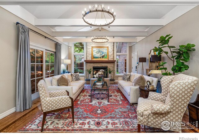 3000 E Cedar Ave Unit 2, Denver, CO 80209 - living room featuring a chandelier, wood finished floors, beamed ceiling, and a warm lit fireplace