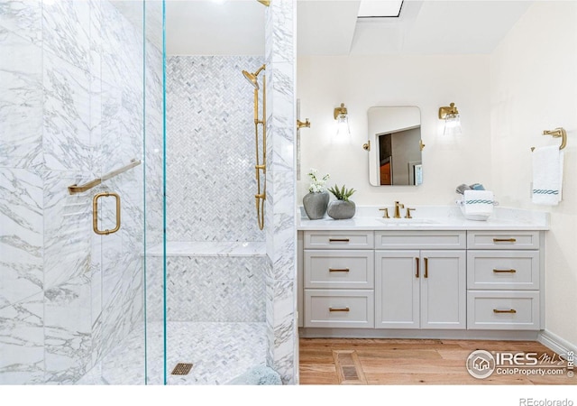 3000 E Cedar Ave Unit 2, Denver, CO 80209 - full bathroom featuring wood finished floors, a marble finish shower, and vanity