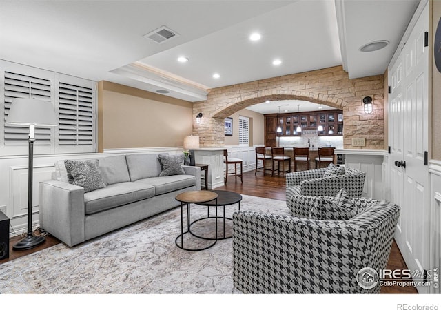 3000 E Cedar Ave Unit 2, Denver, CO 80209 - living area featuring arched walkways, wood finished floors, a decorative wall, wainscoting, and recessed lighting