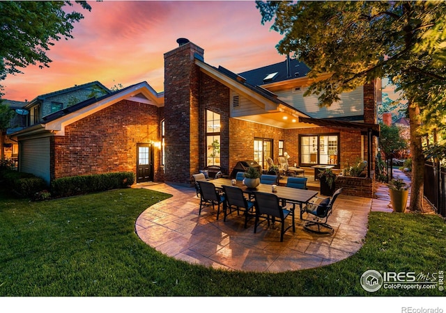 3000 E Cedar Ave Unit 2, Denver, CO 80209 - back of house at dusk with a patio area, a chimney, a yard, and brick siding