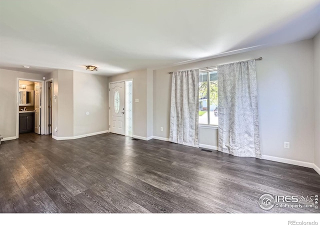 5491 E 117th Ave, Thornton, CO 80233 - unfurnished living room with dark wood-type flooring