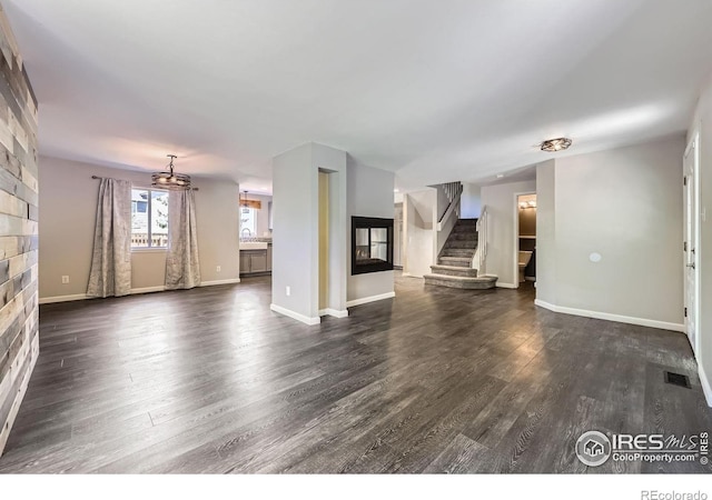 5491 E 117th Ave, Thornton, CO 80233 - unfurnished living room with dark wood-type flooring, stairway, and a large fireplace