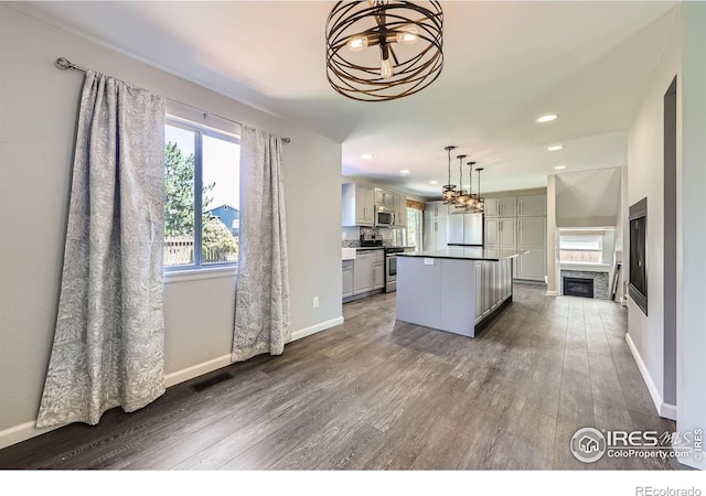 5491 E 117th Ave, Thornton, CO 80233 - kitchen featuring a chandelier, appliances with stainless steel finishes, dark wood-type flooring, a center island, and recessed lighting