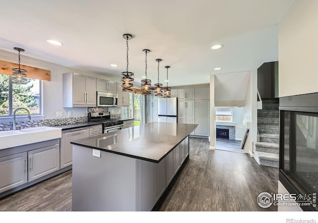 5491 E 117th Ave, Thornton, CO 80233 - kitchen with appliances with stainless steel finishes, gray cabinets, healthy amount of natural light, dark wood-style floors, and recessed lighting
