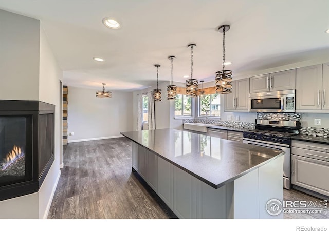 5491 E 117th Ave, Thornton, CO 80233 - kitchen with stainless steel appliances, a kitchen island, gray cabinetry, a chandelier, and recessed lighting