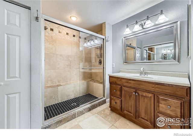 5491 E 117th Ave, Thornton, CO 80233 - full bath with a stall shower, vanity, tile patterned floors, and a textured ceiling