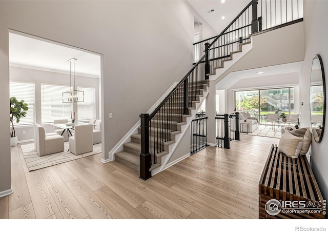 1389 Lyons Ln, Erie, CO 80516 - staircase with wood finished floors, a chandelier, a high ceiling, and recessed lighting
