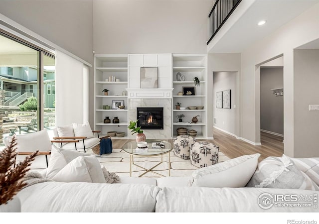 1389 Lyons Ln, Erie, CO 80516 - living area with a towering ceiling, wood finished floors, and a tiled fireplace