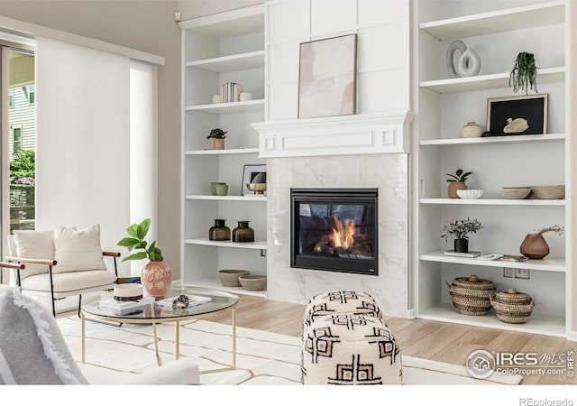 1389 Lyons Ln, Erie, CO 80516 - living room featuring wood finished floors, a premium fireplace, and built in shelves