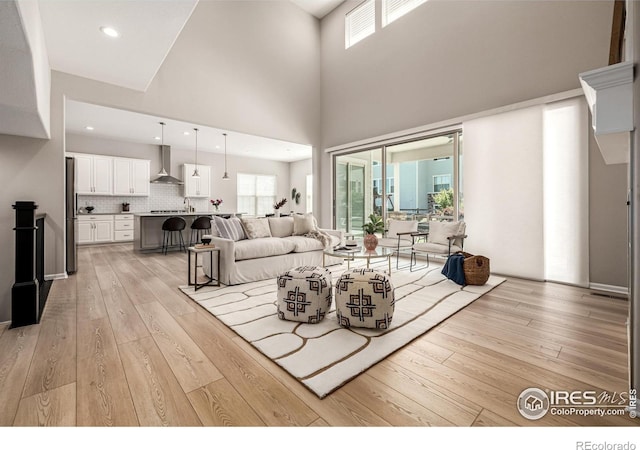 1389 Lyons Ln, Erie, CO 80516 - living area featuring light wood-type flooring, plenty of natural light, a towering ceiling, and recessed lighting