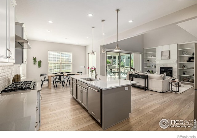 1389 Lyons Ln, Erie, CO 80516 - kitchen with gray cabinetry, stainless steel appliances, light wood-style flooring, an island with sink, and recessed lighting