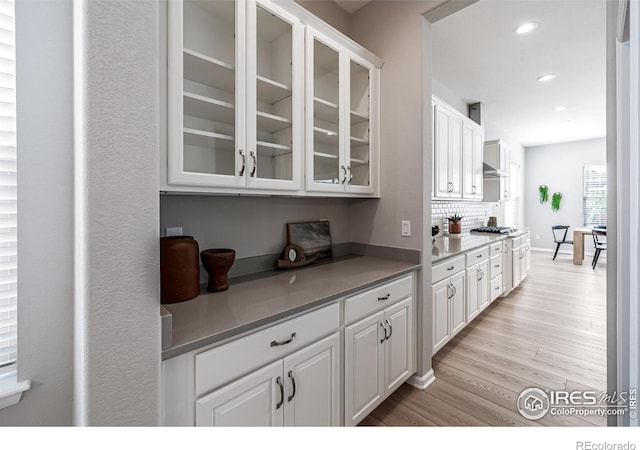 1389 Lyons Ln, Erie, CO 80516 - bar area featuring light wood-type flooring, recessed lighting, tasteful backsplash, and stainless steel gas cooktop