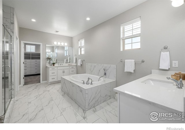 1389 Lyons Ln, Erie, CO 80516 - full bath featuring marble look tiles, two vanities, a garden tub, a marble finish shower, and recessed lighting