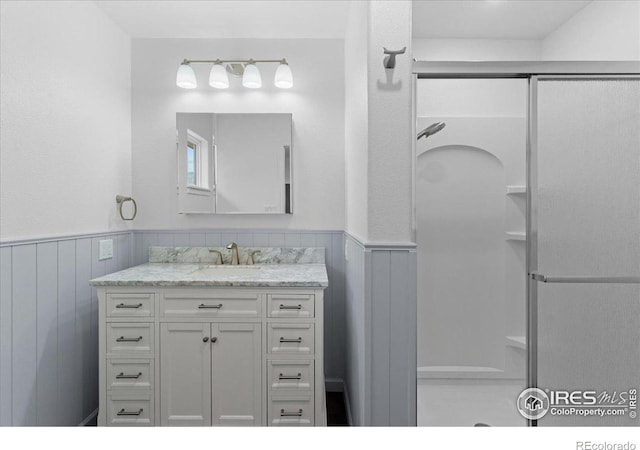 3400 Erving Ct, Berthoud, CO 80513 - bathroom featuring a shower stall, vanity, wainscoting, and wood walls