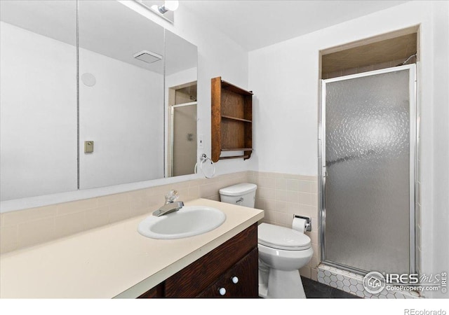 3400 Erving Ct, Berthoud, CO 80513 - bathroom featuring vanity, a stall shower, tile walls, and wainscoting