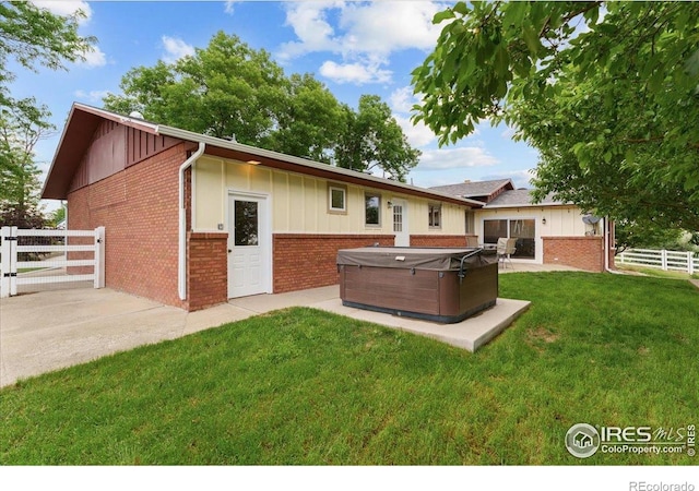 3400 Erving Ct, Berthoud, CO 80513 - rear view of property with a hot tub, brick siding, board and batten siding, and a patio area