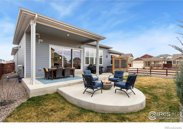 2156 Setting Sun Dr, Windsor, CO 80550 - back of property featuring an outdoor fire pit, a patio, and a fenced backyard