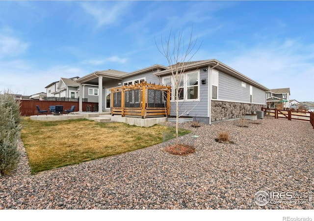 2156 Setting Sun Dr, Windsor, CO 80550 - rear view of property featuring a patio area, a wooden deck, and stone siding