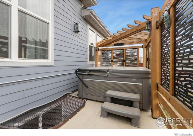 2156 Setting Sun Dr, Windsor, CO 80550 - view of patio / terrace with a hot tub and a pergola