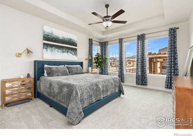 2156 Setting Sun Dr, Windsor, CO 80550 - carpeted bedroom with a tray ceiling and ceiling fan
