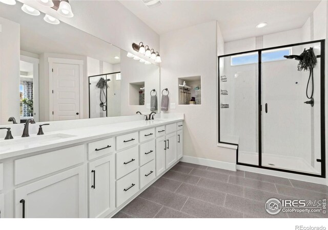 2156 Setting Sun Dr, Windsor, CO 80550 - bathroom with a stall shower, double vanity, healthy amount of natural light, and tile patterned floors
