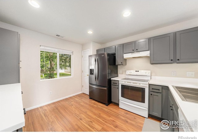 3314 Planter Way, Fort Collins, CO 80526 - kitchen featuring stainless steel fridge, white electric range, under cabinet range hood, gray cabinets, and light wood-type flooring