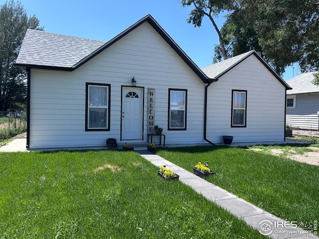 809 Warren St, Weldona, CO 80653 - view of front of home with a shingled roof and a front lawn