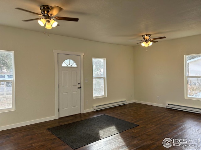 809 Warren St, Weldona, CO 80653 - foyer featuring baseboard heating, ceiling fan, healthy amount of natural light, and dark wood-style floors