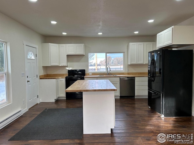 809 Warren St, Weldona, CO 80653 - kitchen with black appliances, a baseboard heating unit, recessed lighting, white cabinetry, and a center island