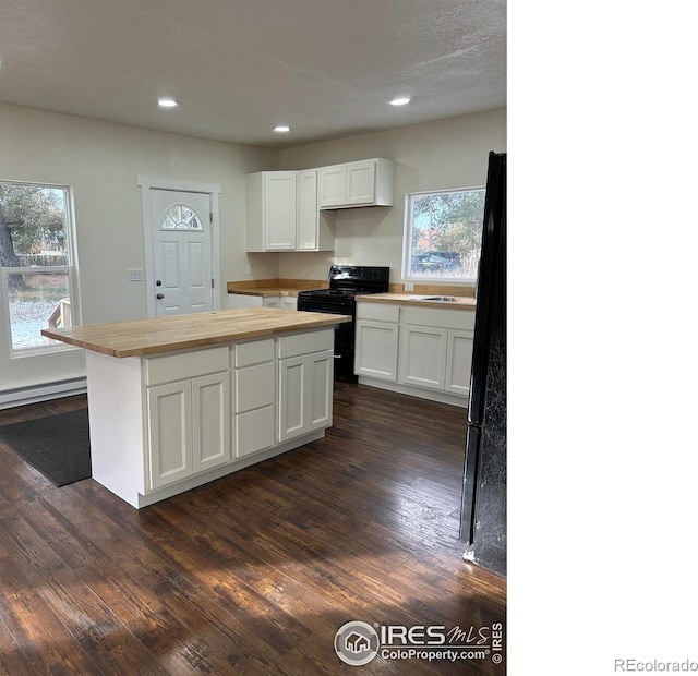 809 Warren St, Weldona, CO 80653 - kitchen with black electric range, butcher block countertops, white cabinetry, dark wood finished floors, and recessed lighting