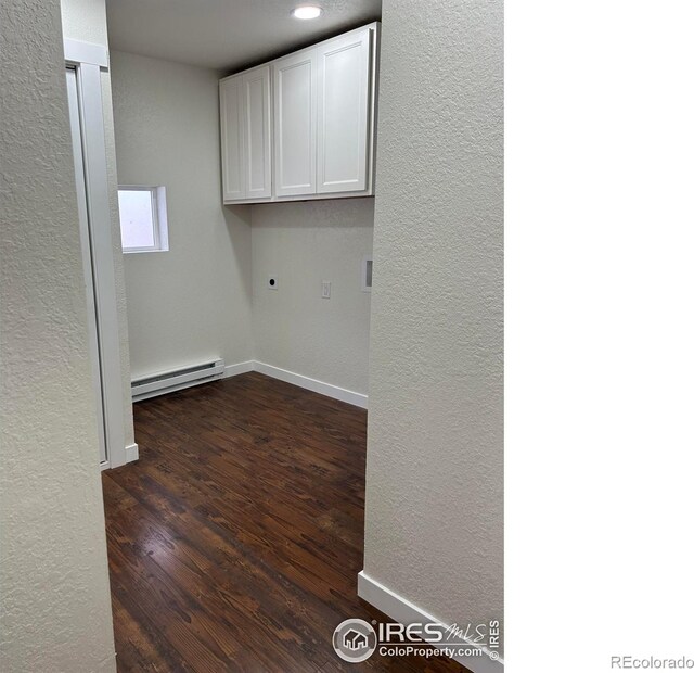 809 Warren St, Weldona, CO 80653 - laundry area with baseboard heating, a textured wall, hookup for an electric dryer, cabinet space, and dark wood finished floors