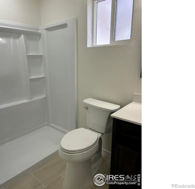 809 Warren St, Weldona, CO 80653 - bathroom with a textured wall, vanity, and a shower