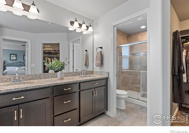 6042 Carmon Dr, Windsor, CO 80550 - bathroom with a walk in closet, double vanity, a shower stall, and ensuite bathroom
