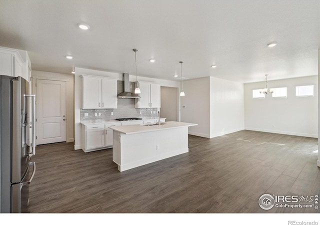 1842 Chaffee Crest Dr, Berthoud, CO 80513 - kitchen featuring appliances with stainless steel finishes, wall chimney exhaust hood, decorative backsplash, dark wood-type flooring, and white cabinets