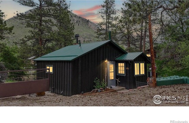 30 Falls Creek Dr, Bellvue, CO 80512 - property exterior at dusk with board and batten siding, a metal roof, and a mountain view