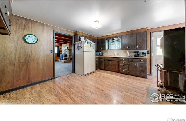 30 Falls Creek Dr, Bellvue, CO 80512 - kitchen featuring freestanding refrigerator, wood walls, dark brown cabinetry, light countertops, and stainless steel microwave