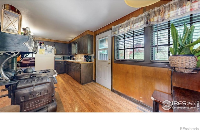30 Falls Creek Dr, Bellvue, CO 80512 - kitchen featuring freestanding refrigerator, light wood finished floors, dark brown cabinets, stainless steel microwave, and wooden walls