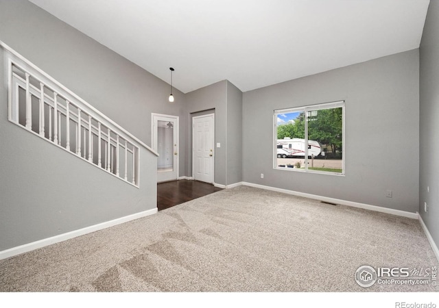 4740 Everglade Ct, Greeley, CO 80634 - foyer featuring dark carpet, vaulted ceiling, and stairway