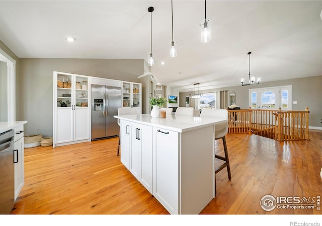 34427 County Rd W, Hillrose, CO 80733 - kitchen with appliances with stainless steel finishes, lofted ceiling, white cabinetry, and light wood-style flooring