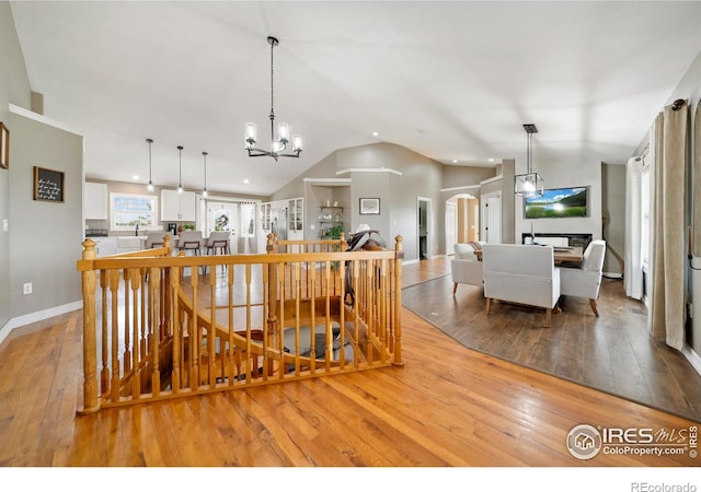 34427 County Rd W, Hillrose, CO 80733 - kitchen with lofted ceiling, light wood finished floors, white cabinets, a chandelier, and recessed lighting