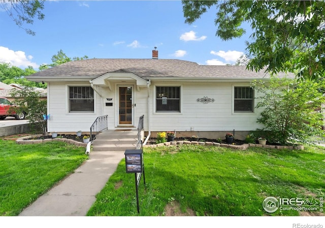 1417 14th St, Greeley, CO 80631 - view of front of home featuring a front yard, a chimney, and roof with shingles