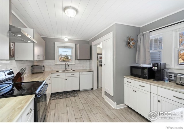 1417 14th St, Greeley, CO 80631 - kitchen featuring black appliances, wall chimney exhaust hood, decorative backsplash, light countertops, and crown molding