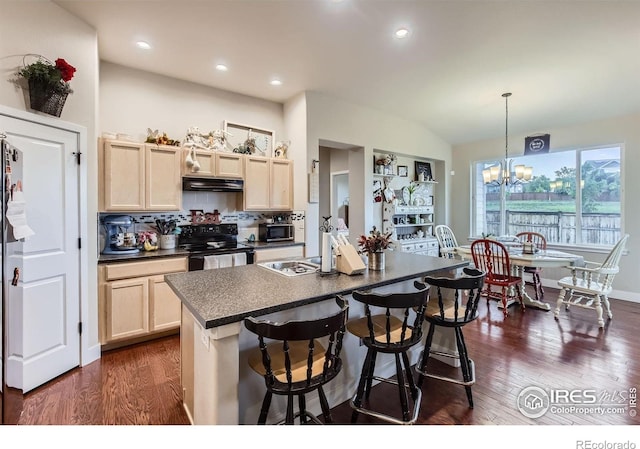 825 Forest Canyon Rd, Severance, CO 80550 - kitchen with black / electric stove, under cabinet range hood, dark countertops, light brown cabinetry, and stainless steel microwave