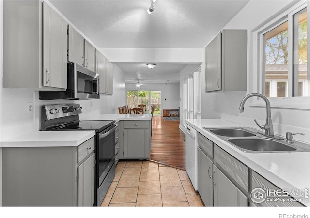 3421 Surrey Ln, Fort Collins, CO 80524 - kitchen featuring stainless steel appliances, gray cabinetry, a ceiling fan, light countertops, and light tile patterned floors
