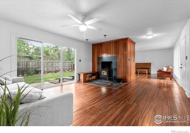 3421 Surrey Ln, Fort Collins, CO 80524 - living area with a wood stove, ceiling fan, wood finished floors, and a textured ceiling